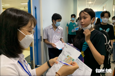 Cán bộ coi thi gọi thí sinh vào phòng thi trong kỳ thi đánh giá năng lực do Đại học Quốc gia TP.HCM tổ chức năm 2022 - Ảnh: Trần Huỳnh