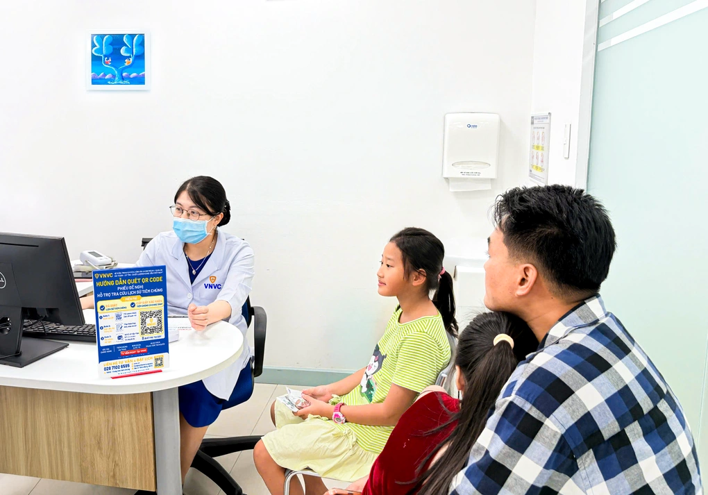 Một gia đình đưa hai con đến rà soát lịch sử tiêm chủng và được tư vấn các mũi cần bổ sung trước năm học mới.
