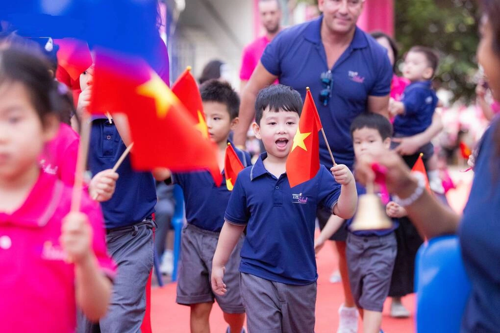 Học sinh tiểu học được thầy cô đưa vào trường trong lễ khai giảng.