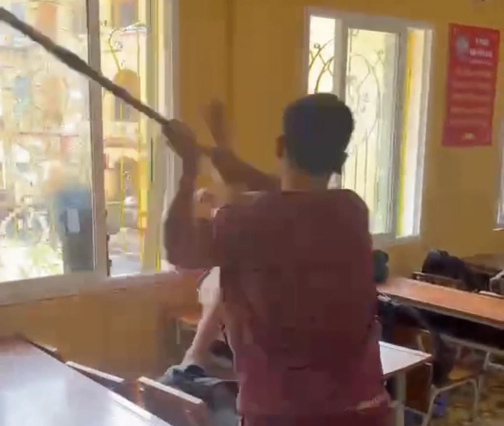 Nam sinh dùng chổi đánh bạn. Ảnh cắt từ video