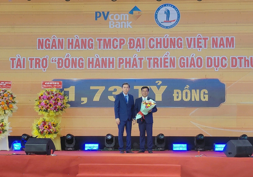 Tiến sĩ Trương Tấn Đạt, Hiệu trưởng trường Đại học Đồng Tháp (trái) tặng hoa cho nhà tài trợ.